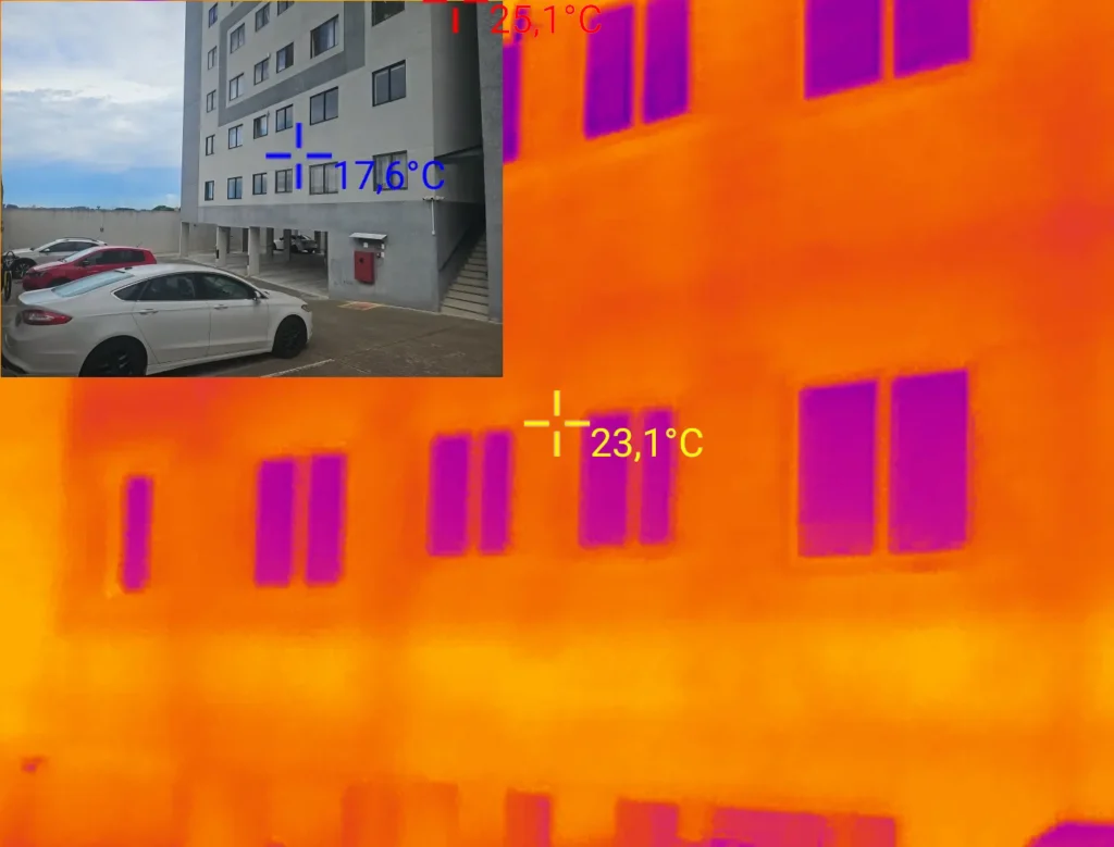 Imagem termográfica de fachada com padrões térmicos distintos próximos aos vãos das janelas.