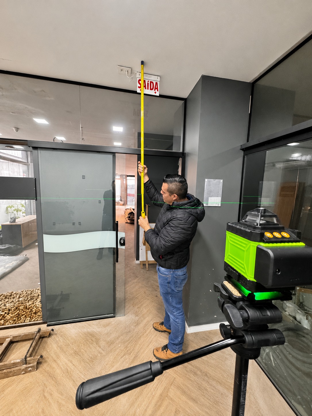 Engenheiro Vallero realizando medição técnica em vistoria com trena e nível a laser para assistência técnica pericial.