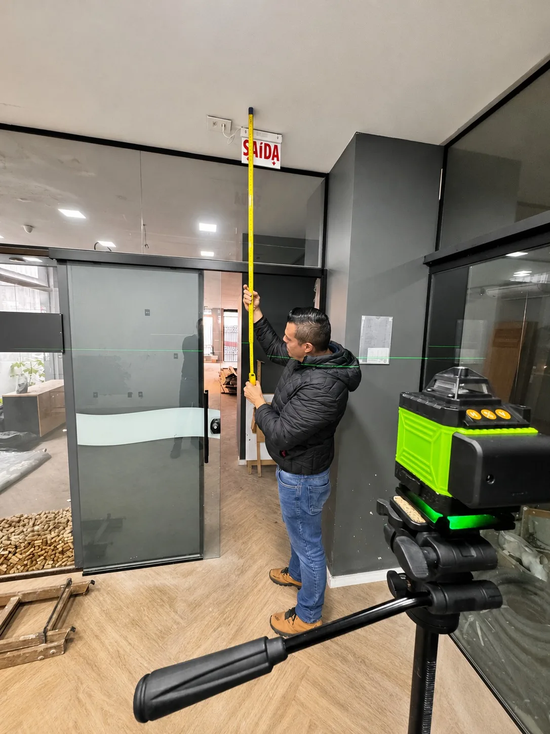 Engenheiro Vallero em medição técnica com nível a laser e trena para assistência técnica pericial